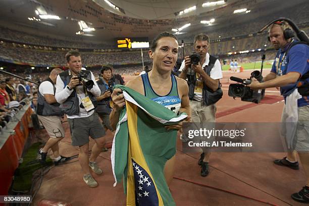 Summer Olympics: Brazil Maurren Higa Maggi victorious with flag after winning Women's Long Jump Final gold at National Stadium . Beijing, China...
