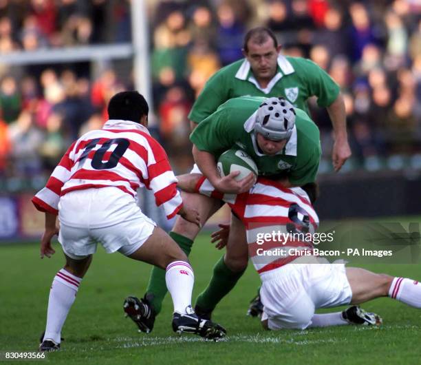 Ireland's Anthony Foley is brought down by Katsuji Ohara and Keiji Hirose of Japan during the International friendly at Lansdowne Road, Dublin.