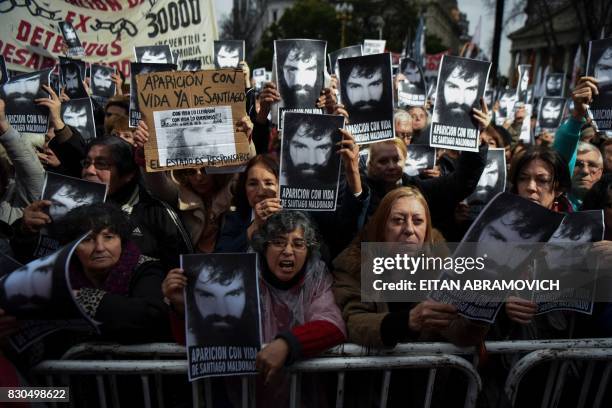 People hold portraits of activist Santiago Maldonado -disappeared on August 1st during a Mapuche protest in Chubut province, during a demonstration...