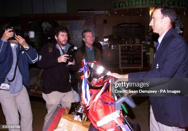 Photographers gather around England cricket captain Nasser Hussain arrives back at Heathrow airport from Pakistan after England beat Pakistan in the...