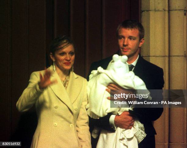 American singer Madonna and British film director Guy Ritchie with their four-month-old baby son Rocco, wrapped in a white christening gown, after...