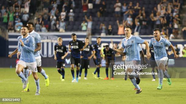 Sporting KC players rush to celebrate with goalkeeper Tim Melia after he stopped a penalty kick to win the Lamar Hunt US Open Cup semifinal against...