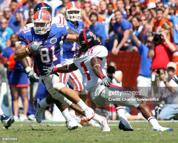 Wide receiver Aaron Hernandez of the Florida Gators catches a pass for a large gain while avoiding safety Kendrick Lewis of the Mississippi Rebels...