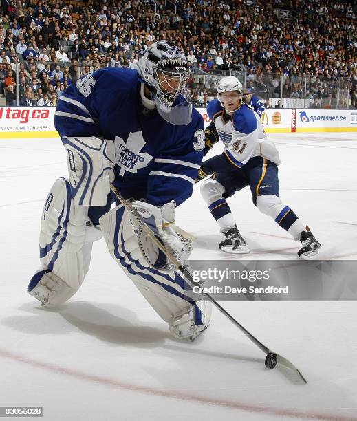 Vesa Toskala of the Toronto Maple Leafs plays the puck as Steve Regier of the St. Louis Blues defends during a preseason NHL game at the Air Canada...