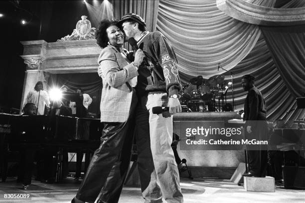 April 1993: Smokey Robinson, right, gives Aretha Franklin a kiss on stage at a rehearsal for the "Aretha Franklin: Duets" concert to benefit the Gay...