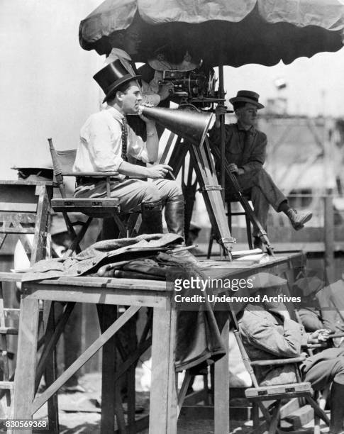 Director Rex Ingram with megaphone, cigar, top hat and knee-high boots at work on the set of 'The Four Horsemen of the Apocalypse' starring Rudolph...