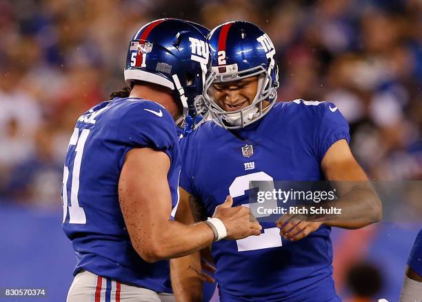 Kicker Aldrick Rosas of the New York Giants is congratulated by Zak DeOssie after kicking a 52 yard field goal during the second quarter of an NFL...