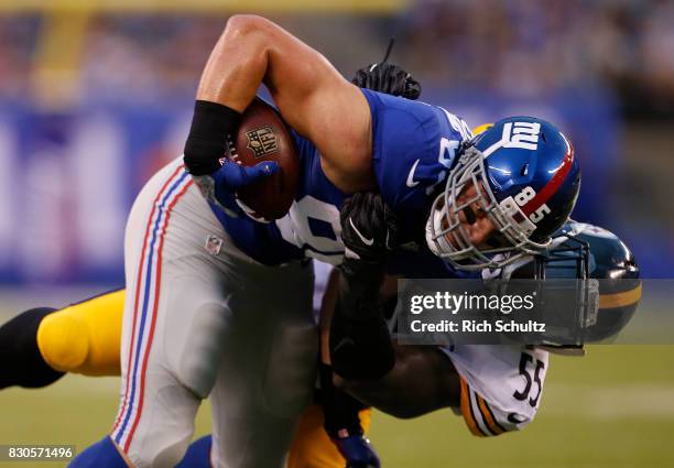 Rhett Ellison of the New York Giants is tackled by Arthur Moats of the Pittsburgh Steelers after making a catch during the first quarter of an NFL...