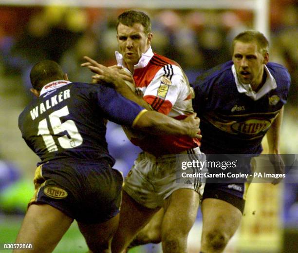 Wigan's Paul Johnson breaks through the tackles of Leeds's Chev Walker and Andy Hay at the JJB Stadium, during their Tetley Bitter Super Leage match...