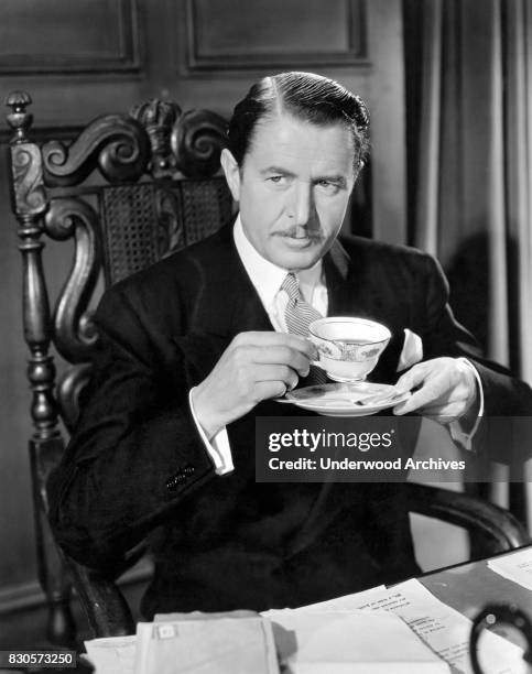 Reginald Owen has a cup of coffee in the MGM comedy, 'Personal Property,' Hollywood, California, 1937.