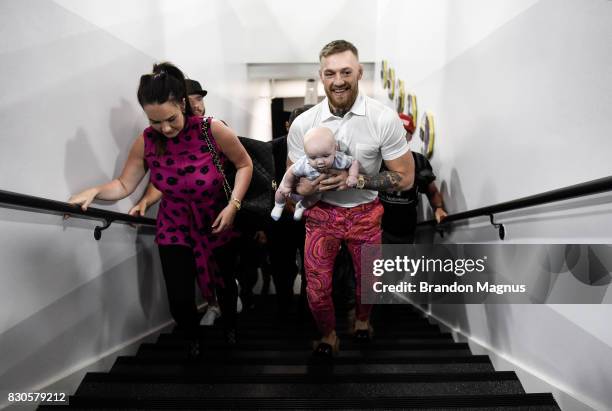 Lightweight champion Conor McGregor walks with his girlfriend Dee Devlin and son Conor McGregor Junior during a media workout at the UFC Performance...