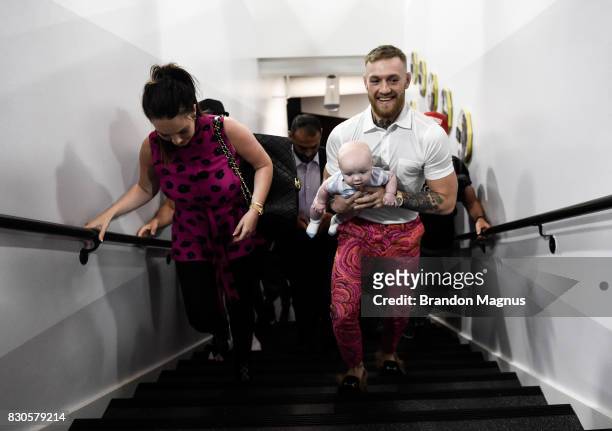 Lightweight champion Conor McGregor walks with his girlfriend Dee Devlin and son Conor McGregor Junior during a media workout at the UFC Performance...