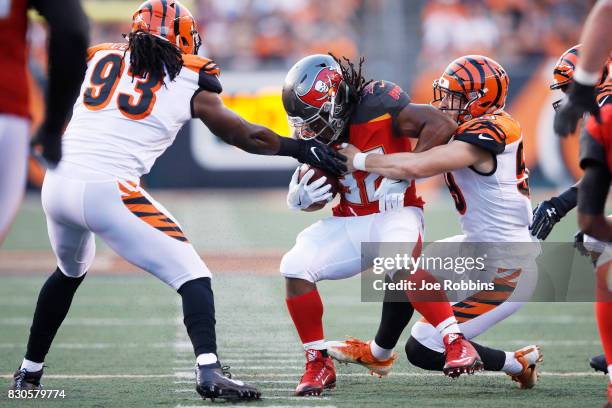 Nick Vigil and Will Clarke of the Cincinnati Bengals tackle Jacquizz Rodgers of the Tampa Bay Buccaneers in the first quarter of a preseason game...