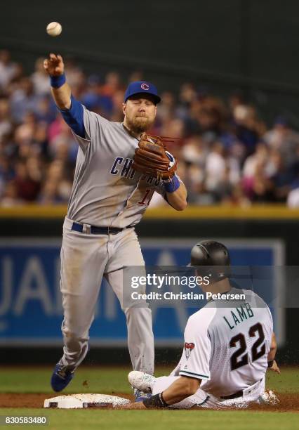 Infielder Ben Zobrist of the Chicago Cubs throws over the sliding Jake Lamb of the Arizona Diamondbacks to complete a double play during the first...