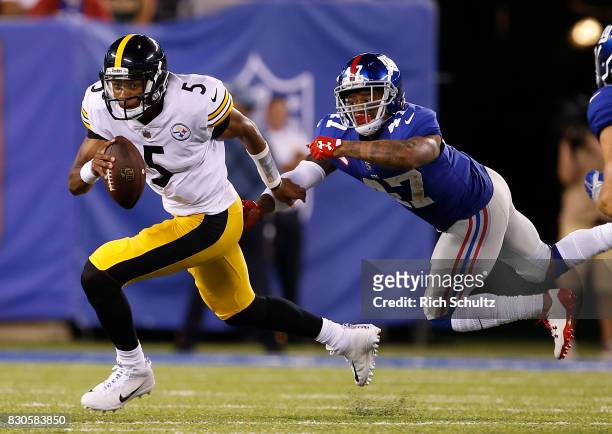 Quarterback Joshua Dobbs of the Pittsburgh Steelers escapes the grasp of Valentino Blake of the New York Giants during the third quarter of an NFL...