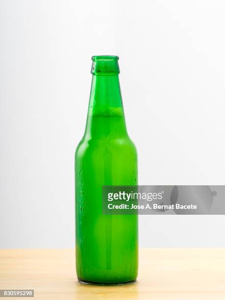 bottle of  beer with the glass esmerilado with drops of water and a steam cloud frozen on a white bottom - beer mat stockfoto's en -beelden