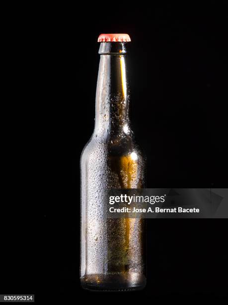 bottle of beer with the glass esmerilado with drops of water and a steam cloud frozen on a black bottom - beer mat stockfoto's en -beelden