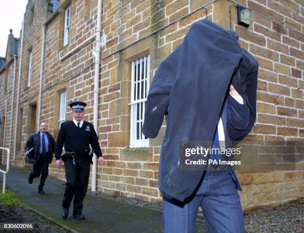 Robert Podesta leaves Dornoch Sheriff Court in Scotland with a friend after he fined 1000 for secretly filming the star-studded christening of...