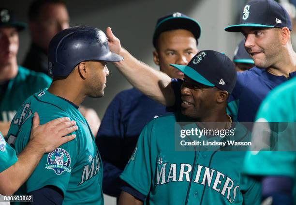 Nelson Cruz of the Seattle Mariners, left, is greeted by teammates in the dugout after scoring in the sixth inning, including Guillermo Heredia,...