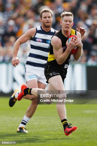 Jack Riewoldt of the Tigers marks the ball against Lachie Henderson of the Cats during the round 21 AFL match between the Geelong Cats and the...