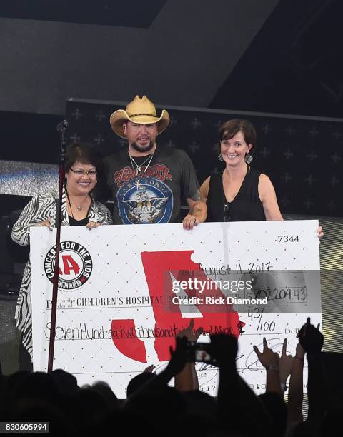 Singer/Songwriter Jason Aldean signs and presents check to President/CEO Childrens Hospital Hospital - Navicent Hospital Dr. Ninfa M. Saunders and...