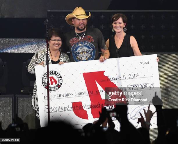 Singer/Songwriter Jason Aldean signs and presents check to President/CEO Childrens Hospital Hospital - Navicent Hospital Dr. Ninfa M. Saunders and...