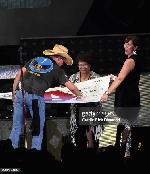 Singer/Songwriter Jason Aldean signs and presents check to President/CEO Childrens Hospital Hospital - Navicent Hospital Dr. Ninfa M. Saunders and...