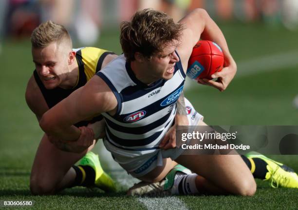Brandon Ellis of the Tigers tackles Jake Kolodjashnij of the Cats during the round 21 AFL match between the Geelong Cats and the Richmond Tigers at...
