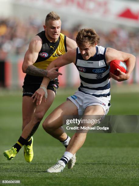 Brandon Ellis of the Tigers tackles Jake Kolodjashnij of the Cats during the round 21 AFL match between the Geelong Cats and the Richmond Tigers at...