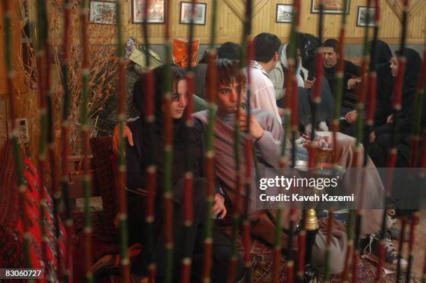 Young man smokes a hookah with his girlfriend in a teahouse in Darband, in the foothills of north Tehran, 19th March 2004. People go to Darband to...