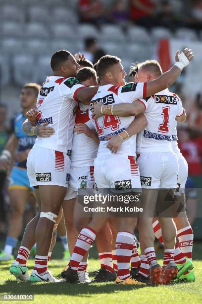 The Dragons congratulate Kurt Mann of the Dragons after he scored a try during the round 23 NRL match between the St George Illawarra Dragons and the...