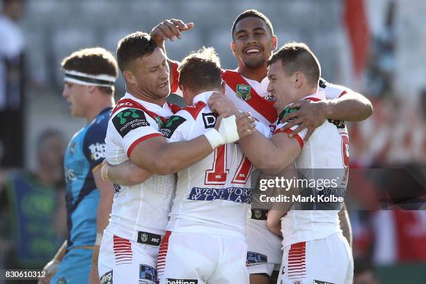 Tariq Sims, Nene MacDonald and Cameron McInnes of the Dragons celebrate with Kurt Mann of the Dragons after he scored a try during the round 23 NRL...