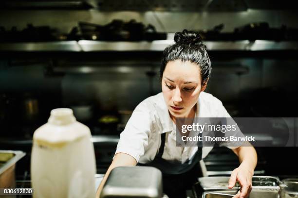 female chef preparing for dinner service in restaurant kitchen - woman chef stock pictures, royalty-free photos & images