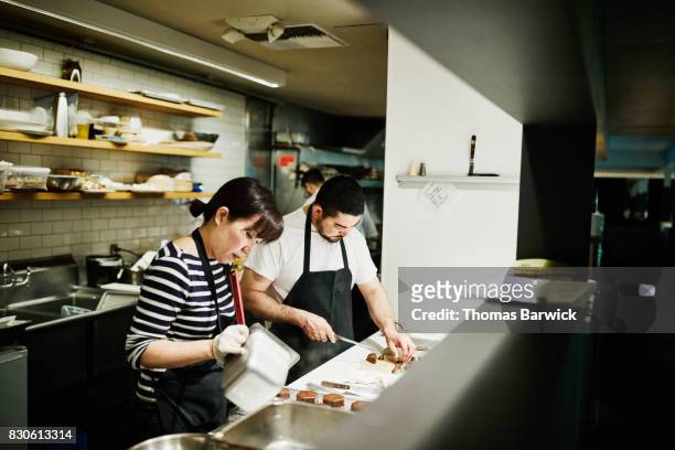pastry chefs preparing desserts for dinner service in restaurant kitchen - chef patissier stock pictures, royalty-free photos & images