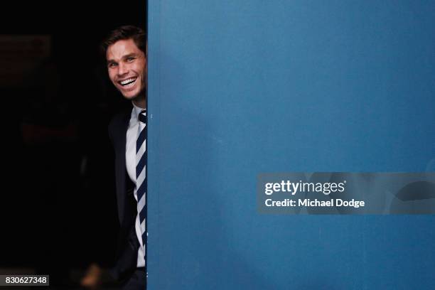 Tom Hawkins of the Cats, suspended for this week, raises a smile after their win as he waits for teammates to come off the ground during the round 21...