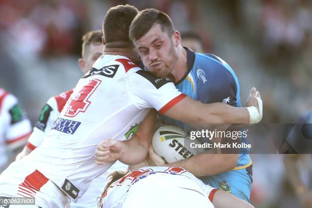 Tariq Sims and Kurt Mann of the Dragons is tackle Joe Greenwood of the Titans during the round 23 NRL match between the St George Illawarra Dragons...