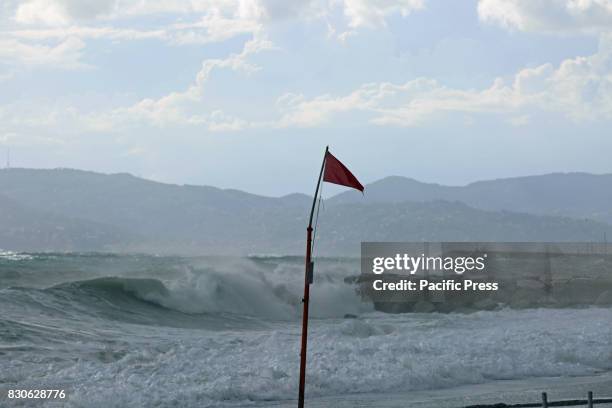 Red flag showing the danger of the sea. A storm surge occurred in the northern region of Italy, Luguria. It wasn't possible to take any bath, because...