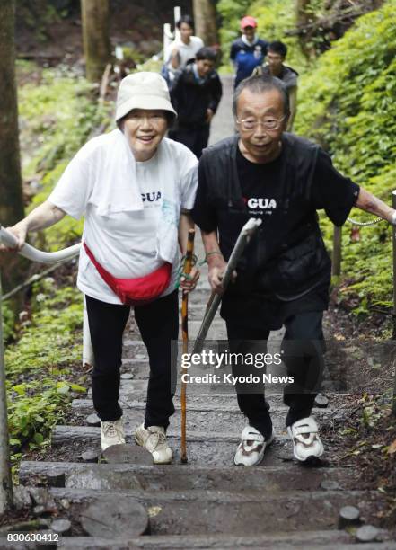 Masanori Takishita and his wife Fumiyo from Tokyo, climb a mountain in Gunma Prefecture, northwest of Tokyo, toward Osutaka Ridge on Aug. 12 the 32nd...