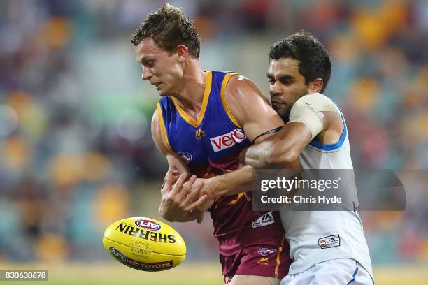 Ryan Lester of the Lions is tackled by Jack Martin of the Suns during the round 21 AFL match between the Brisbane Lions and the Gold Coast Suns at...