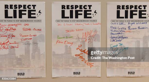 Signatures of kids taking a pledge to end violence including Latee Smith, lower center, hang on a wall at BUILD of Chicago in the Austin neighborhood...