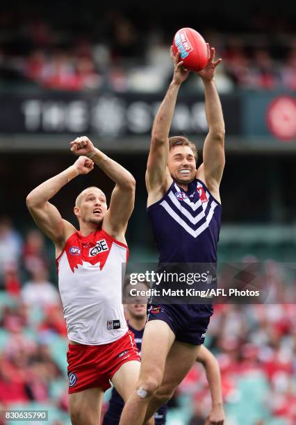 Joel Hamling of the Dockers takes a mark in front of Sam Reid of the Swans during the round 21 AFL match between the Sydney Swans and the Fremantle...