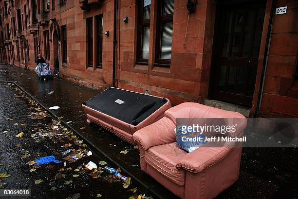 Woman points towards some discarded furniture in a street on September 30, 2008 in the Govan area of Glasgow, Scotland. A report by the Campaign to...