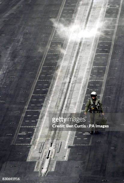 Pilot walks past a cloud of steam on the catapult take-off area on the US aircraft carrier USS Enterprise during a major naval training exercise in...