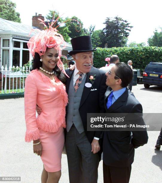 Game show host Bruce Forsyth poses with his wife Wilnelia and jockey Frankie Dettori at the main entrance of the racecourse on Ladies Day, the fourth...