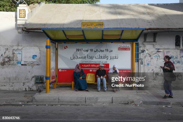 Sensitization poster for registration in the Tunisian municipal elections set for December 17 is seen in a bus stop located behind the building of...