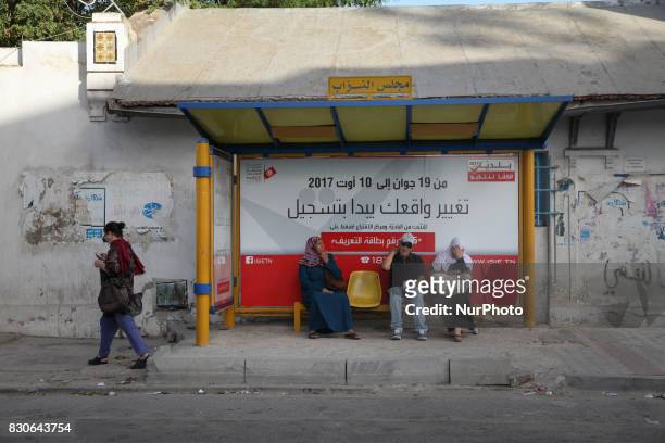 Sensitization poster for registration in the Tunisian municipal elections set for December 17 is seen in a bus stop located behind the building of...