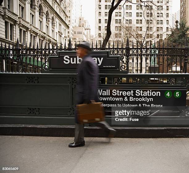 businessman walking past subway station - new york subway station stock pictures, royalty-free photos & images
