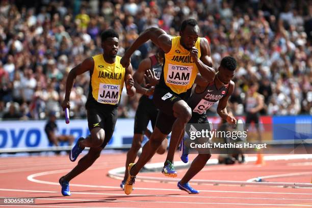 Michael Campbell hands the baton to Usain Bolt of Jamaica in the Men's 4x100 Metres Relay heats during day nine of the 16th IAAF World Athletics...