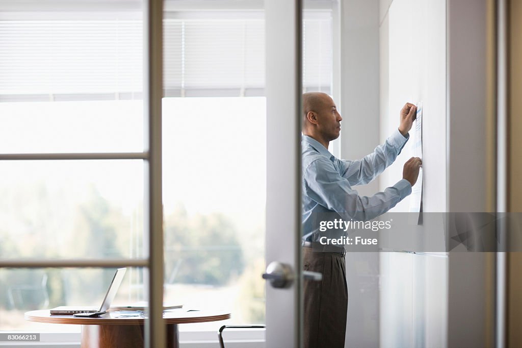 Paper Getting Up Businessman Putting Paper Up On Bulletin Board High-Res Stock Photo ...