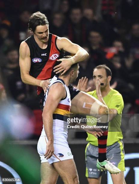 Joe Daniher of the Bombers celebrates a goal by jumping on Rory Atkins of the Crows during the round 21 AFL match between the Essendon Bombers and...